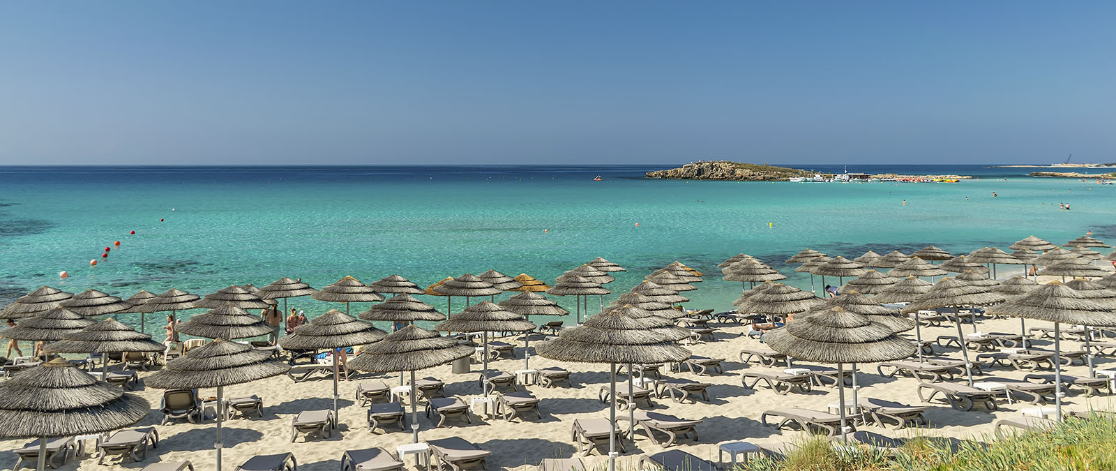 Tourists and locals relax on the famous beach of Nissi in Cyprus.